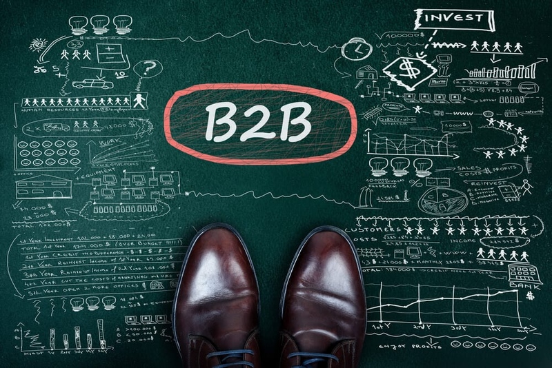 Brown leather shoes on chalkboard surface with B2B and many types of other strategies written and drawn on it