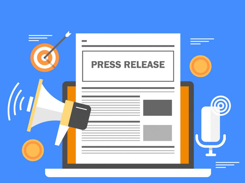 Press release on a laptop with megaphone, microphone, and dartboard