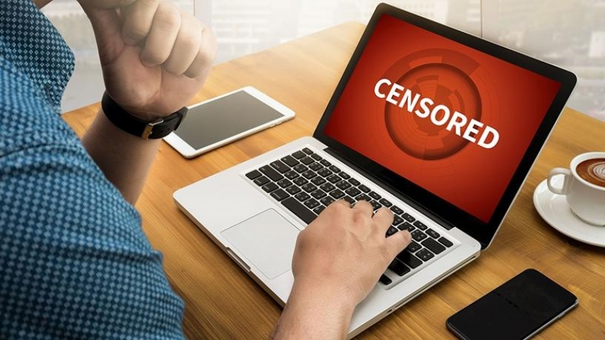 A guy with laptop with a screen showing 'censored'