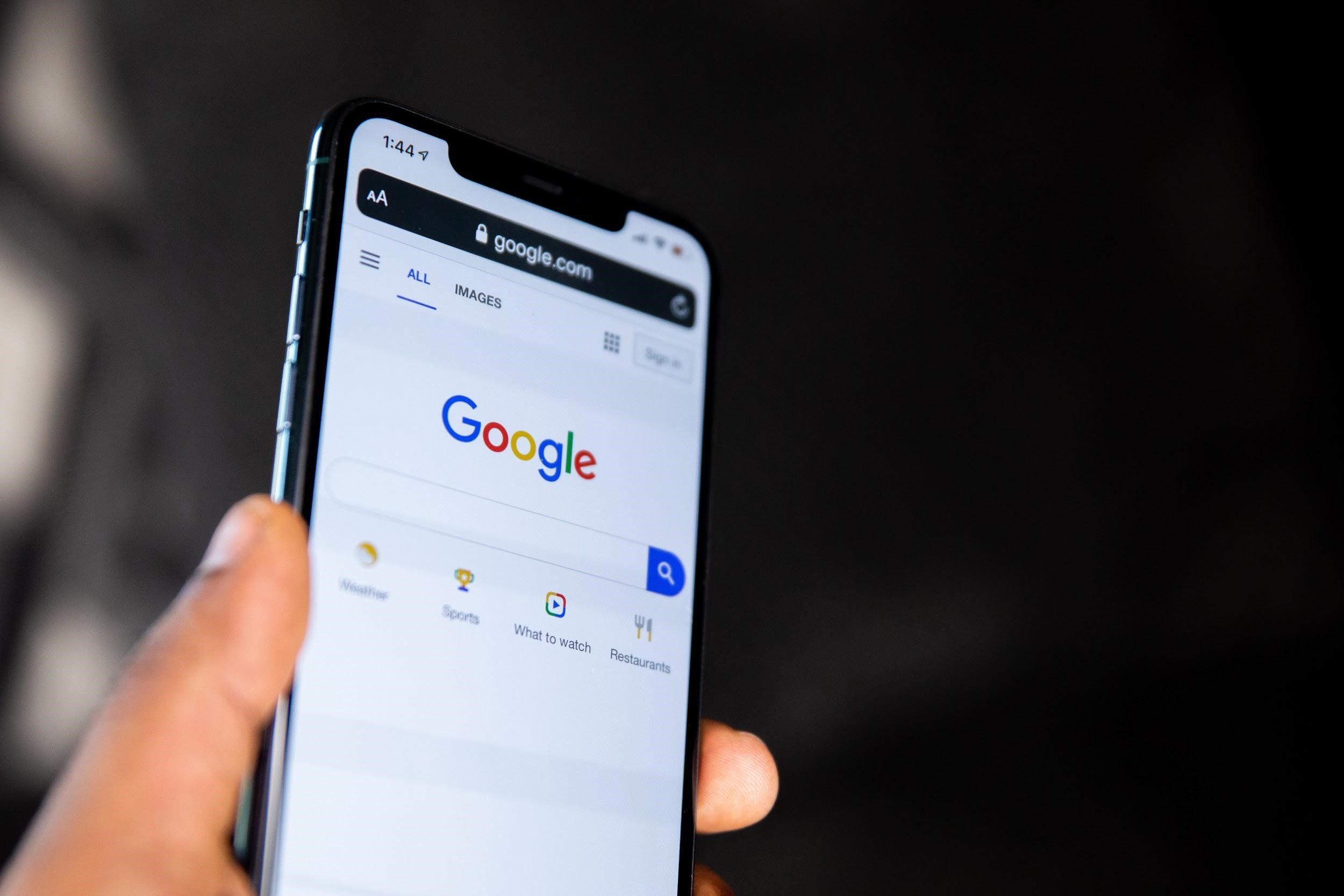Hand holding a phone in a google search engine