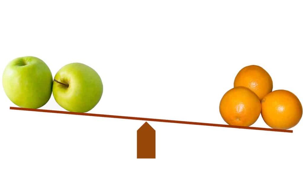 2 green apples and 3 oranges on a weighing scale
