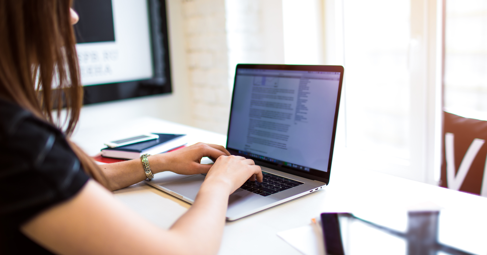 A girl typing in a laptop