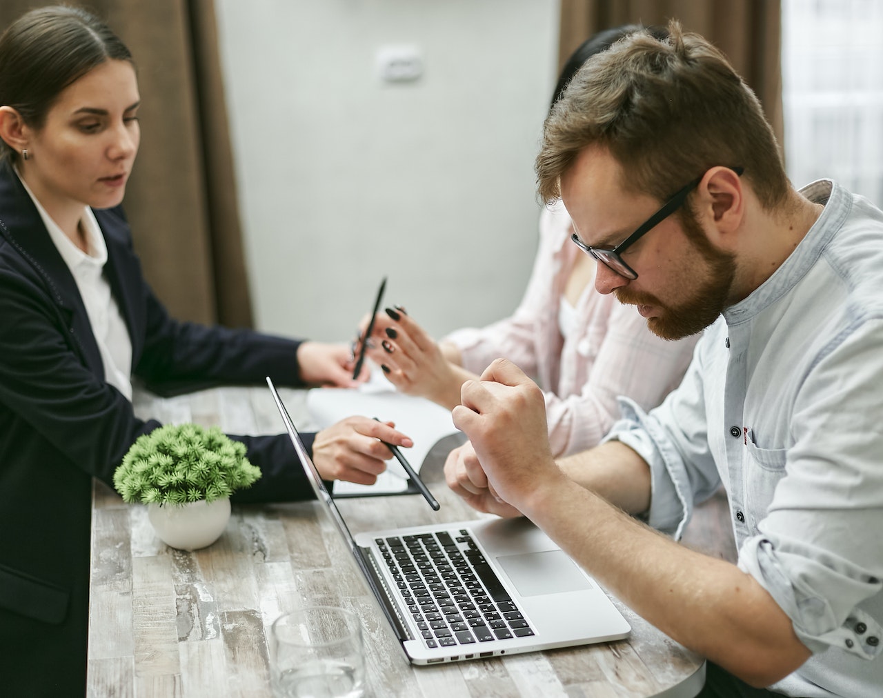 A Bearded Man Looking at the Laptop on the Table