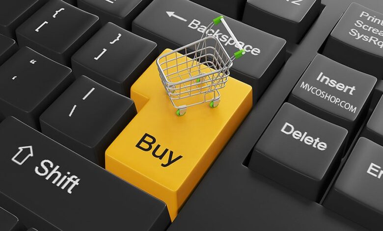 A miniature cart on top of a yellow key on a keyboard labeled buy
