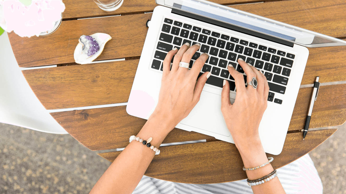Hands typing on a laptop