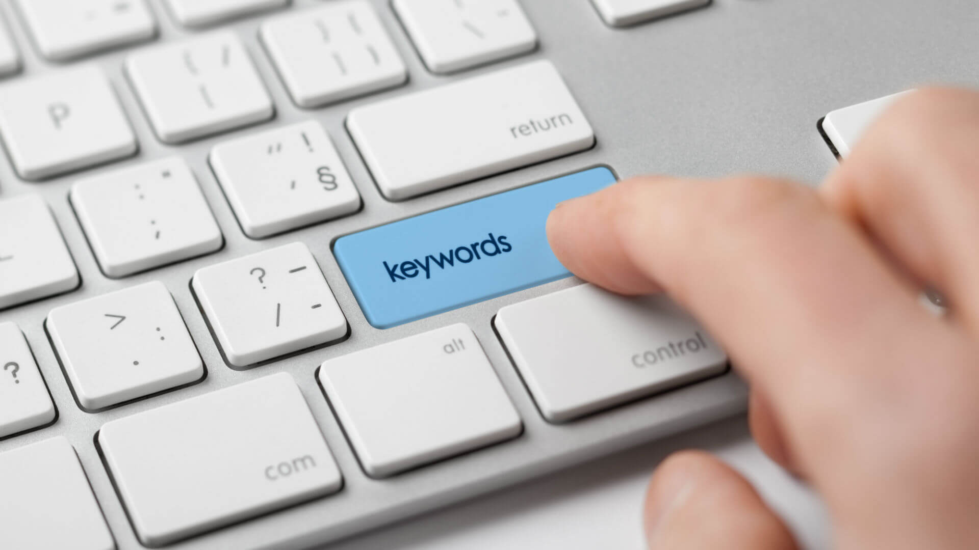 Hand pressing keyword key on a laptop keyboard