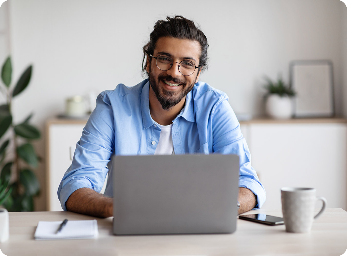 A man wearing a blue polo long sleeves with laptop in front of him