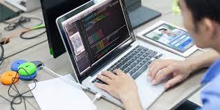 A man typing code on a laptop