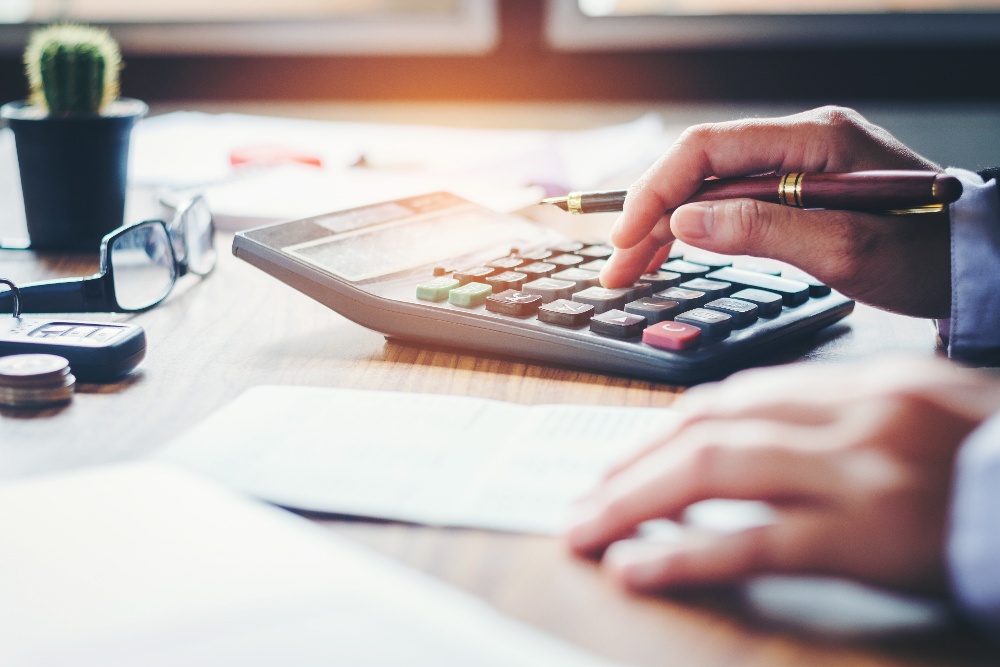 A man using calculator with paper beside it