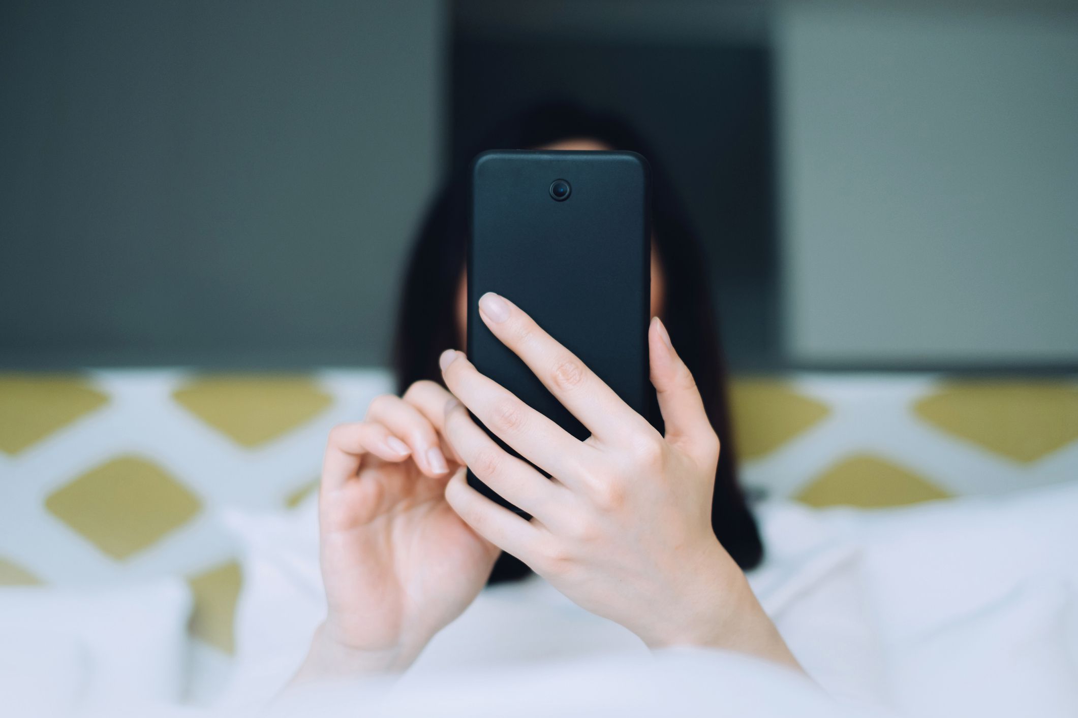 A woman holding a black phone