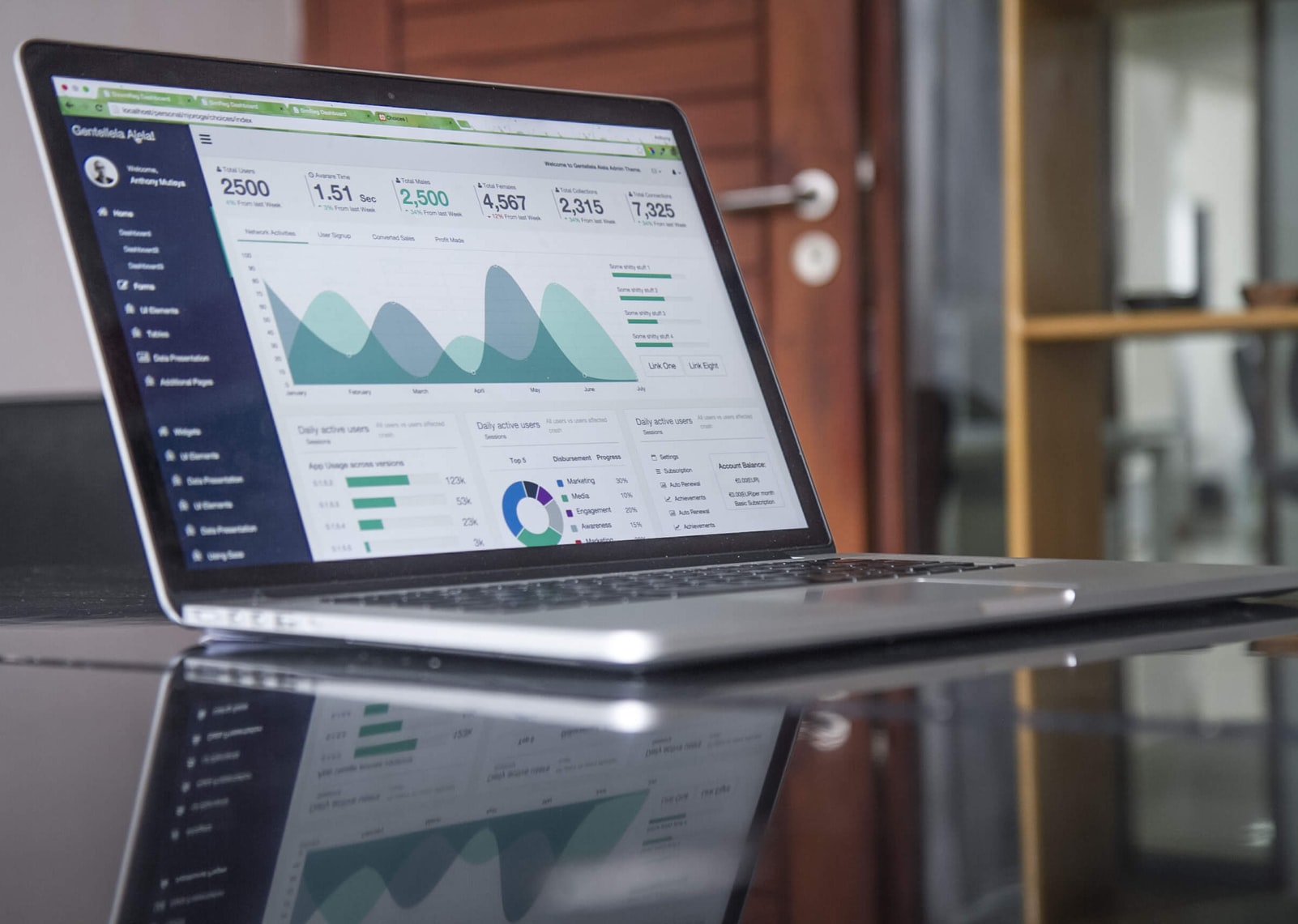 Laptop with graphs on a glass table