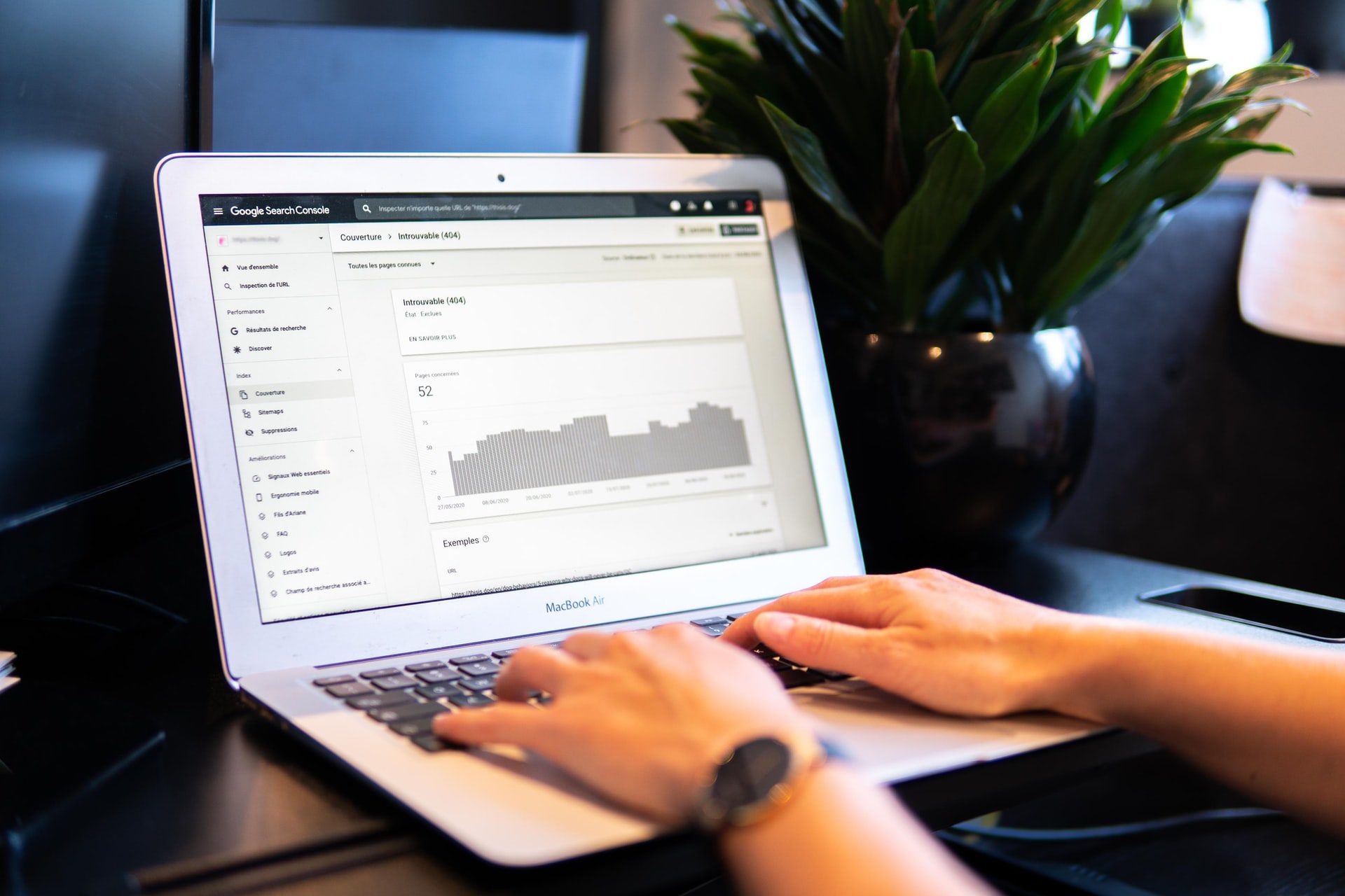 Hands typing on a laptop with bar graph