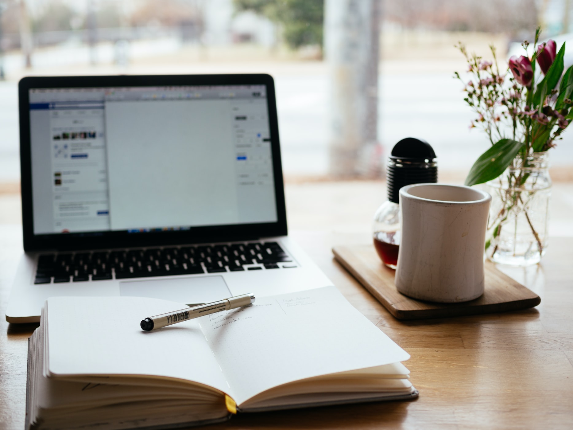 Laptop, notebook, and a white cup
