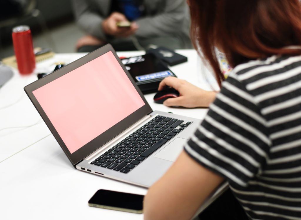 A woman wearing a black and white stripes using a laptop