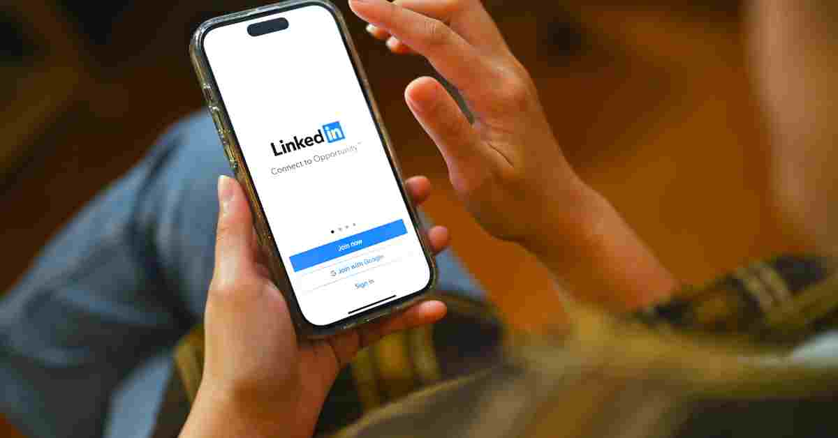 A person holding a phone with LinkedIn app