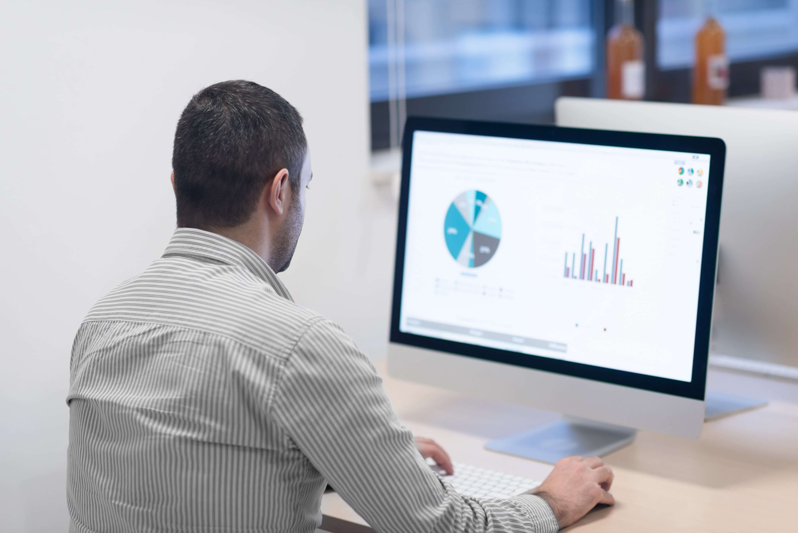 A man looking at the monitor with graphs