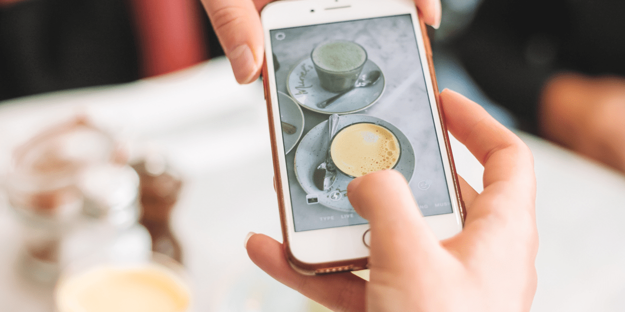 A person taking a picture of a coffee